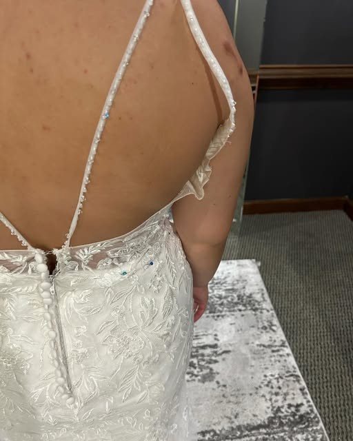Lace gown with a button-back being fitted
